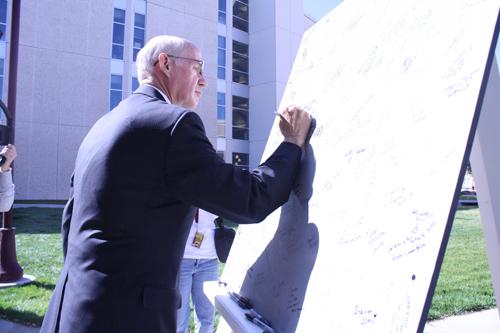 Dr. O’Brien signs the time capsule lid. Photo by Krystina Martinez.