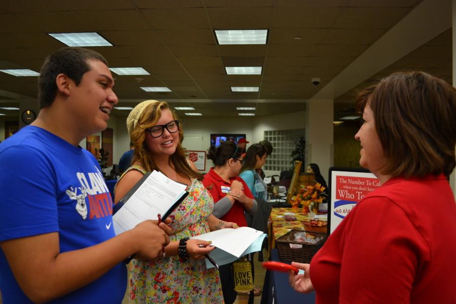 Alex Ceballos (freshman) and Chelsea Urbanczyk (freshman) look for volunteer opportunities with 211 Texas, represented by Danielle Crawford (right). Photo by Alex Montoya.