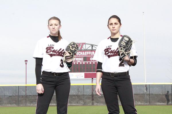 Alyssa Lemos (left) and Mercedes Garcia pose in front of the scoreboard. Photo by Johnny Story and courtesy of WTAMU Athletics.