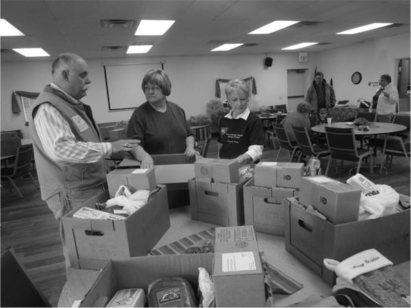 Monte Winders, former WT Alumni Association president, Pastor Debra Huffman and Manna Ministries leader Sandy Russell pack boxes of food for the “Food from Heaven” project. Photo Courtesy of Amanda Rogers.