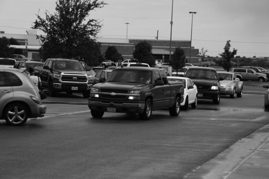 A line of cars form around the parking lot as students search for available spots in the crowded parking lots.