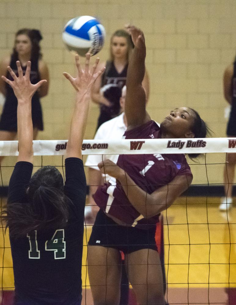 Kamille Jones (right center) hits the ball over an Adams State blocker during the match at the Box on Saturday, Sept. 2