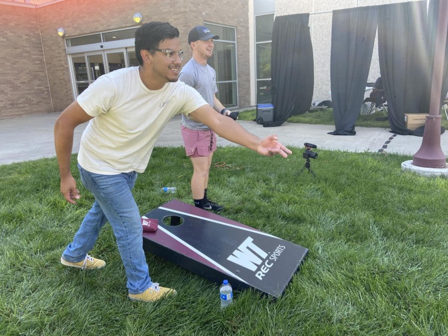 Ky and his teammate having their turn at a corn hole game