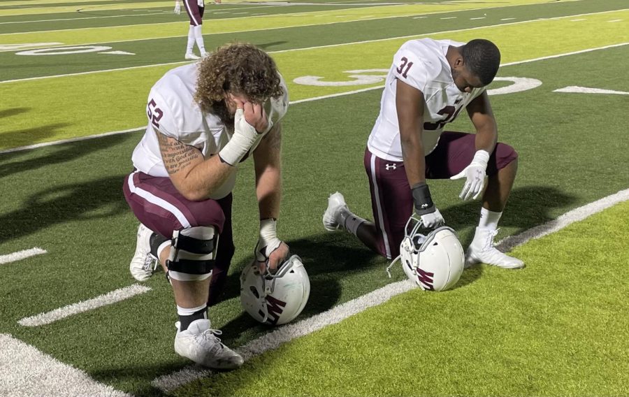 Zane Madison, center, and Christoper Thomas, Linebacker, Kneel in prayer before the game