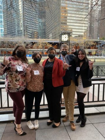 Chicago, IL – Nov 23, 2021: From left to right, Sara King, Madelynn Luckey, Zyna Abjuma, Marcus Rogers and Sharon Quintero-Diaz stand with the WTAMU hand sign on the Chicago Riverwalk during the last day of the AMUN conference.
