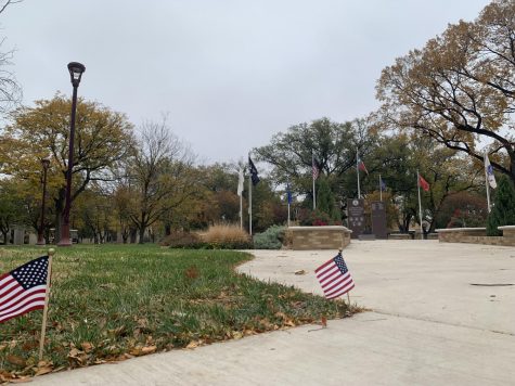 Canyon, TX – Nov 10, 2021: Flags of the branches of the U.S. military float in the light breeze with smaller american flags line the concrete path to the WTAMU Veterans Memorial.