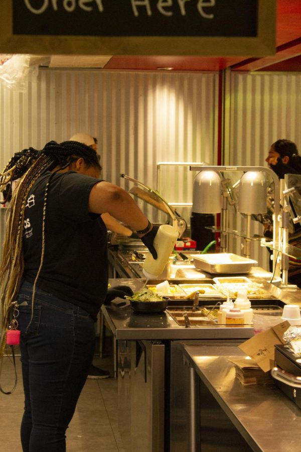 From front to rear: Dominique Ellis and Hannah Womack prepare burrito bowls at Pony Express Burritos. Photo taken March 9, 2022.
