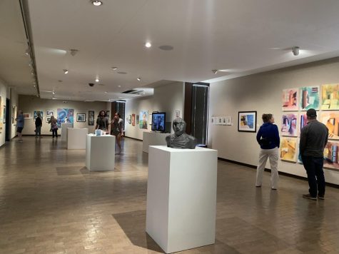 Visitors walk around the WT section of the Student/Faculty Exhibition on the second floor of the Amarillo Museum of Art. Photo taken April 16, 2022.