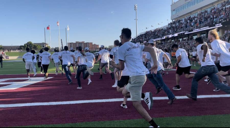 Students take part in the stampede and rush the football field.